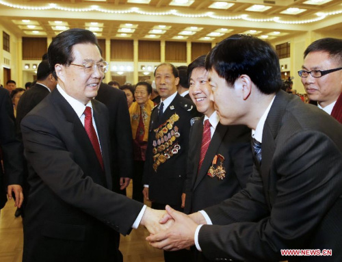 Chinese President Hu Jintao (L) shakes hands with a participant at a Spring Festival reception held by the Central Committee of the Communist Party of China and the State Council (Cabinet) at the Great Hall of the People in Beijing, capital of China, Feb 8, 2013. [Photo/Xinhua]