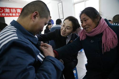 A prosecutor and the mother of a teenager in a reformatory check whether the boy has clothes warm enough to withstand winter weather.