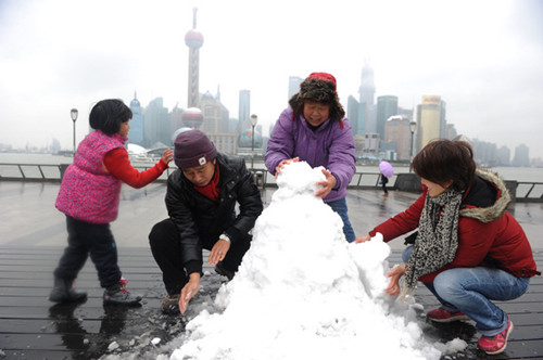 Snow provides an unexpected opportunity for some tourists to unleash their artistic talent on the Bund in Shanghai on Tuesday. [PHOTO BY LAI XINLIN / FOR CHINA DAILY]