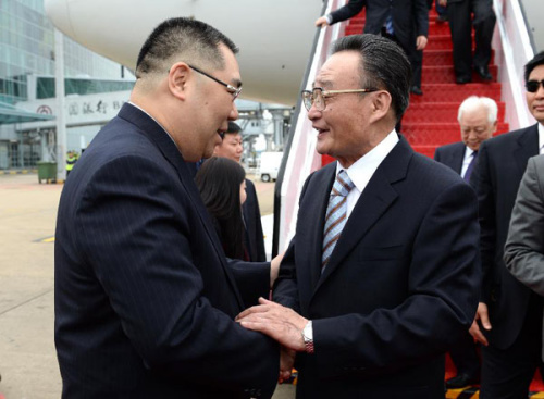 Wu Bangguo (R), chairman of the National People's Congress (NPC) Standing Committee, arrives in the Macao Special Administrative Region (SAR), south China, Feb. 20, 2013. Wu will attend the celebration of the 20th anniversary of the promulgation of Macao's Basic Law. (Xinhua/Ma Zhancheng)