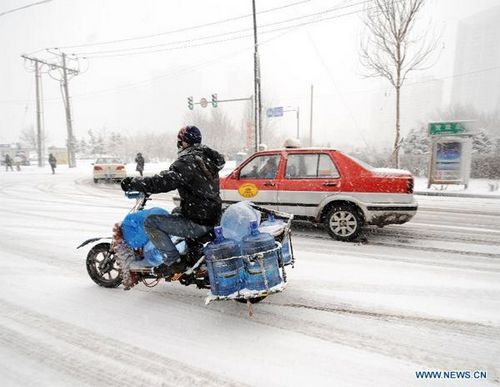 The traffic moves in snow in Shenyang, capital of northeast China's Liaoning Province, Feb. 28, 2013. Liaoning was hit by a snowstorm on Thursday. (Xinhua/Li Gang)