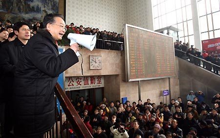 Chinese Premier Wen Jiabao (L) speaks by a loudspeaker to the stranded passengers at the Railway Station of Changsha in central China's Hunan Province on Jan. 29, 2008. (Xinhua File Photo)