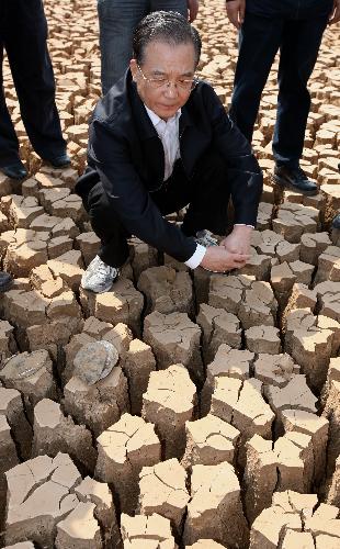 Chinese Premier Wen Jiabao inspects the cracked bottom of the Degehaizi Reservoir in Luliang County, southwest China's Yunnan Province, March 20, 2010. During a three-day inspection trip in the drought-plagued Yunnan Province ending on Sunday, Premier Wen visited Qujing City, one of the regions that suffered the most from the severe drought ravaging since last October, to comfort the affected locals and direct relief work. (Xinhua File Photo/Yao Dawei)