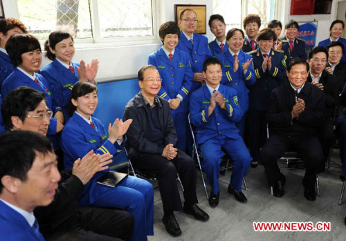 Chinese Premier Wen Jiabao, who is also a member of the Standing Committee of the Political Bureau of the Communist Party of China (CPC) Central Committee, sits together with public transportation workers in Beijing, capital of China, May 1, 2012, or International Labour Day. (Xinhua File Photo/Li Tao)