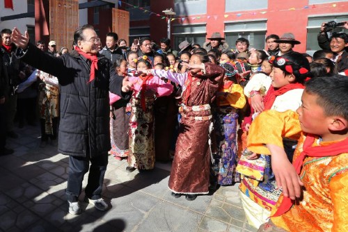 Chinese Premier Wen Jiabao (L front) dances with pupils as he visits the Hongqi Elementary School which has been rebuilt after a devastating earthquake in 2010, in Yushu Tibetan Autonomous Prefecture in northwest China's Qinghai Province, Dec. 31, 2012. Wen paid a visit in quake-hit Yushu before New Year's Day to inspect the reconstruction work and extend New Year's greetings to the people there. (Xinhua File Photo/Yao Dawei)