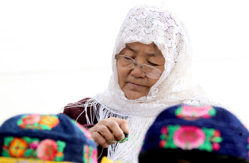 A woman makes stitches embroidery in Huayuan village, March 11, 2013. [Photo/Asianewsphoto]