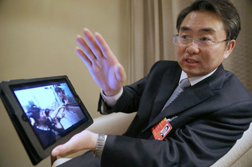 Mu Weimin, an NPC deputy and mayor of Nanyang in Henan province, shows a picture in Beijing of local people relocated to project a water source from Beijing polluted. [Xu Jingjing / China Daily]