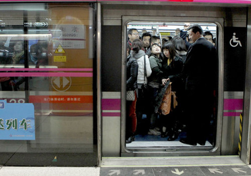 Passengers in a crowded carriage at Dongdan station on the Beijing Subway's Line 5 on Wednesday. The average daily passenger volume for subway lines in early March was 8.4 million. ZHU XINGXIN / CHINA DAILY