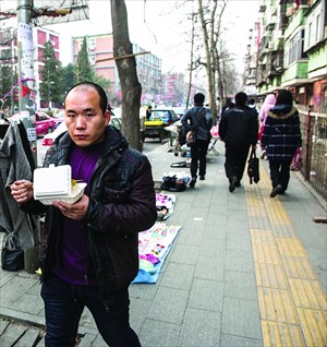 A man eats from a polystyrene food container in Gucheng Xiaojie, Shijingshan district Thursday. Photo: Li Hao/GT 