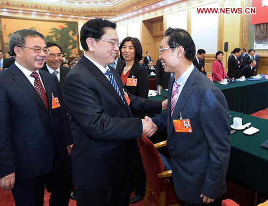 In this file photo taken on March 8, 2013, Zhang Dejiang (C, front) shakes hands with Zhong Nanshan, a deputy to the 12th National People's Congress (NPC), while joining a discussion with deputies attending the first session of the 12th NPC from south China's Guangdong Province, in Beijing, capital of China. (Xinhua/Li Tao)