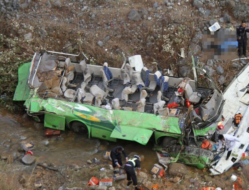 A passenger bus plunges into a ravine beside an expressway in Southwest China's Yunnan province, March 18, 2013. [Photo/Xinhua]