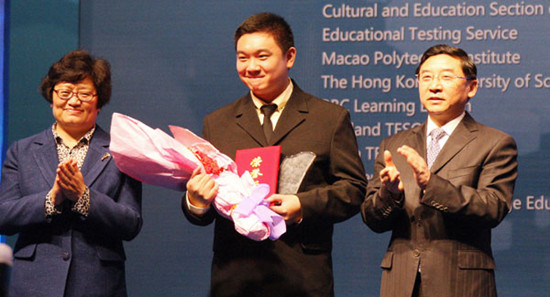 Li Weihong (left), vice-minister of education, and Xiamen Party chief Yu Weiguo present the top prize to Wu Po-te (center) from Fu Jen Catholic University in Taiwan, at the award ceremony of the 18th 21st Century Coca-Cola Cup National English Speaking Competition on Sunday in Xiamen, Fujian province. Hu Meidong / China Daily