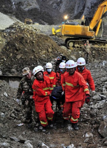 Firefighters carry a body at the site where a large-scale landslide hit a mining area in Maizhokunggar County of Lhasa, southwest China's Tibet Autonomous Region, March 30, 2013.  (Xinhua/Chogo) 