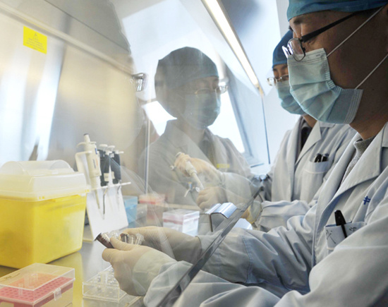 Medics conduct tests on samples of the H7N9 fl u virus at a lab at Beijing's Center of Disease Control and Prevention on Wednesday. [Photo/Xinhua]