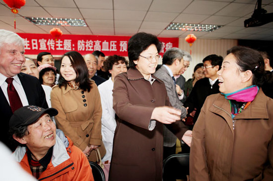 Li Bin, minister in charge of the National Health and Family Planning Commission, chats with residents on Sunday at Zhanlanlu Community Health Center in Beijing, where an activity was organized to prevent high blood pressure. Wang Jing / China Daily