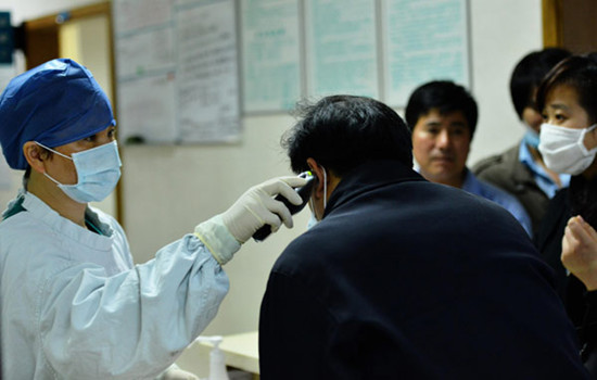 A doctor examines a patient at a fever clinic at the No 1 Hospital of Zhejiang University in Hangzhou. Long Wei / Xinhua