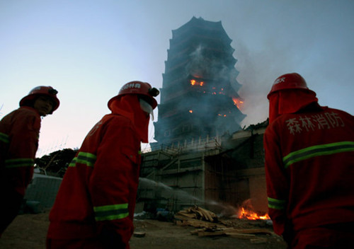 Firefighters battle a fire on Yongding Tower, one of the major buildings of the Ninth China (Beijing) International Garden Expo, on Monday. Wang Jing / China Daily