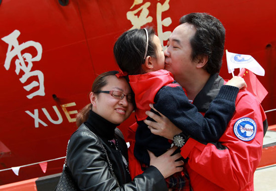 Tang Jingdong, a member of the expedition team sent to Antarctica, kisses his daughter upon his return in Shanghai on Tuesday. Pei Xin / Xinhua 