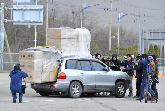 Members of ROK media surround a car with workers returning from the Kaesong Industrial Park, at the gate of the inter-Korean transit office in the border city of Paju on Tuesday. Kim Jae-Hwan / Associated Press