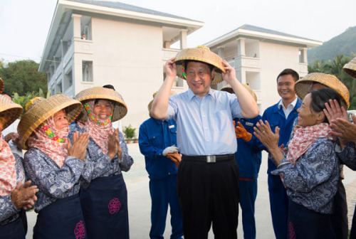 President Xi Jinping puts on a bamboo hat, traditionally donned by ethnic Li people in Sanya on Tuesday, during his visit to the southernmost island province of Hainan. Photo by Li Xueren / Xinhua