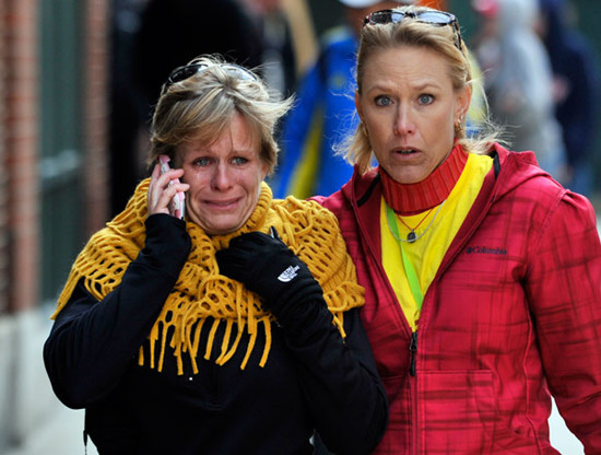 Two women walk from the area where a bomb exploded during the Boston Marathon on Monday, killing at least three and wounding more than 170. [Photo/Agencies]