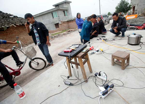 Cellphones and a laptop being recharged at an electric supply station in Lushan county, Sichuan province, on April 21 2013. [CHEN ZHUO/FOR CHINA DAILY]