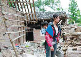 Hu Xia, 29, and her 2-year-old daughter at their destroyed house in Wuxing.