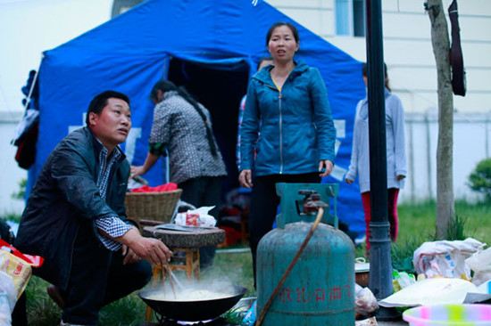 Bai Huaping (left) boils noodles for the rescue team. Feng Yongbin / China Daily