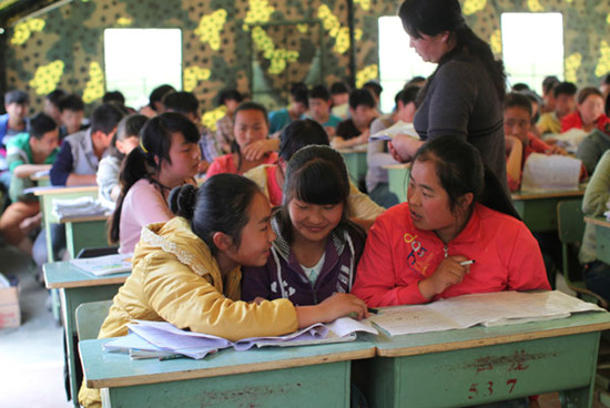 Ninth-grade students of Longmen Middle School in a makeshift classroom in Lushan, Sichuan province, on Wednesday. WANG JING / CHINA DAILY