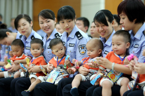 Female police officers in Fangchenggang in the Guangxi Zhuang autonomous region hold babies set to be handed over to Vietnam on Friday. Ten babies, rescued from kidnappers and traffickers, were returned to Vietnam to be reunited with their families. [Photo/Xinhua]