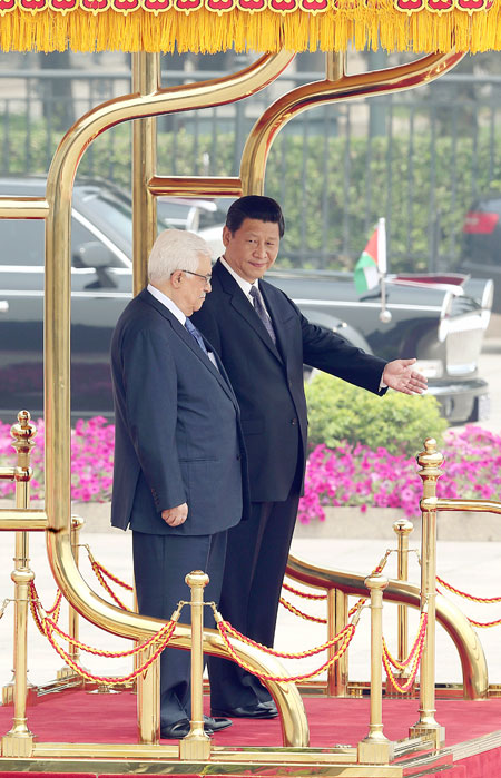 President Xi Jinping welcomes his Palestinian counterpart Mahmoud Abbas outside the Great Hall of the People in Beijing on Monday. Photo by Xu Jingxing / China Daily