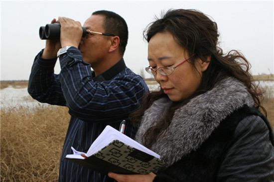 Miao Chunlin (right), head of the protection station of the Nanhai Wetland Reserve, gathers bird migration data. Provided to China Daily