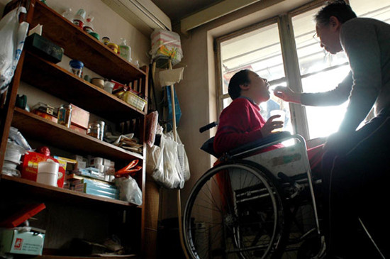 Zhu Mingxin, 72, helps administer Zhu Ling's medicine. Zhu's elderly parents begin their busy 'work schedule' at 7 am every day. Provided to China Daily