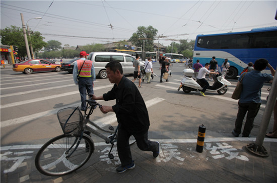 A crossroad in Beijing's Di'anmen area. A new regulation came into force on Monday allowing police to fine people who cross the road recklessly, either on foot or by bike, in an attempt to improve traffic safety in the city. [Photo by Wang Jing / China Daily]