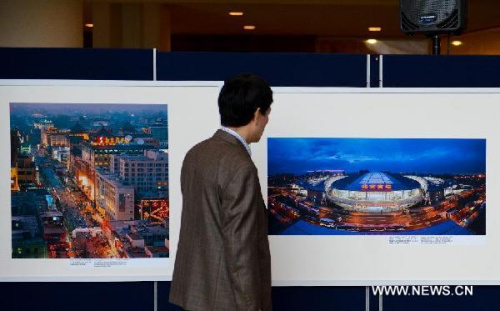 A visitor looks at pictures on display during an exhibition promoting tourism of Chinese capital city Beijing, at the United Nations headquarters in New York, on May 8, 2013. (Xinhua/Niu Xiaolei)  