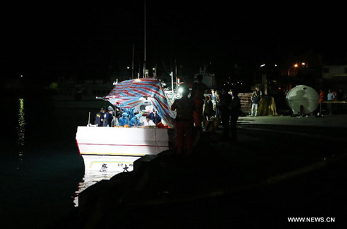 Forensic personnel check the body of a Taiwanese fisherman on fishing vessel Guang Ta Hsin 28, which was fired upon by Philippine coast guard, at a fishing port of Pingtung County, southeast China's Taiwan, in the early morning on May 11, 2013. The body of the Taiwanese fisherman, killed in the shooting incident by Philippine coast guard on the sea on Thursday morning, was taken home with the fishing vessel. The 65-year-old victim, Hung Shih-Cheng, was one of four crew members onboard. The rest of the crew survived the shooting uninjured. (Xinhua/Chen Jun)