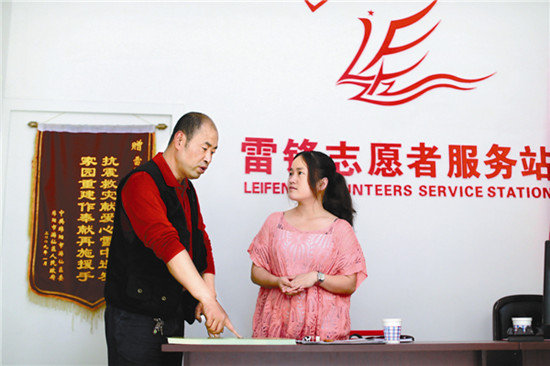 Li Zhenping (left) and his assistant Zhang Pengfei at Leifeng Volunteer Service Station, which he founded in 2008. [Photo by Feng Yongbin / China Daily]