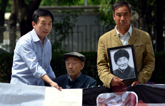 Zhang Shijie, 89, forced to labor by Japanese company Mitsubishi during World War II, and other victims or their relatives protest outside the Japanese embassy in Beijing on Monday. FAN JIWEN / FOR CHINA DAILY