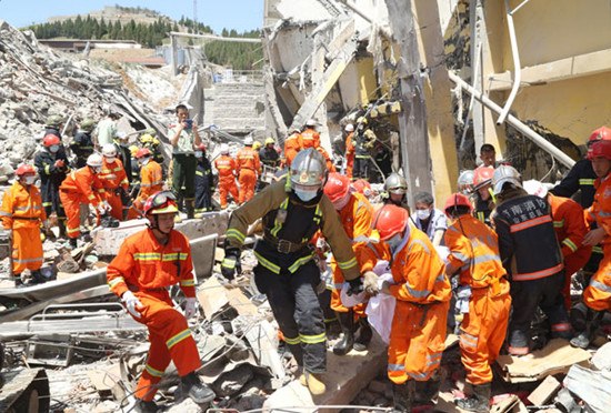 Rescuers pull a person out of the debris of a collapsed workshop after a massive blast ripped through a factory on Monday in Zhangqiu, Shandong province. The explosion killed 13 people. Provided to China Daily