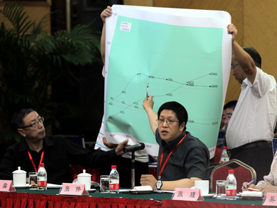 Zhang Wei, an official at the Beijing transport commission, displays statistics at a hearing on Thursday on a possible taxi-fare increase. WANG JING/CHINA DAILY