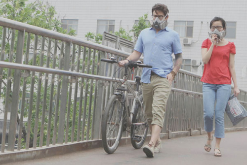 A couple walk in the haze wearing breathing masks at an overpass near Beijing Forestry University. ZHU XINGXIN/ CHINA DAILY