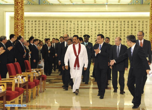 Chinese Premier Li Keqiang (R) shakes hands with President of Sri Lanka Mahinda Rajapaksa (L) during a meeting with him in Beijing, capital of China, May 29, 2013. (Xinhua/Rao Aimin)