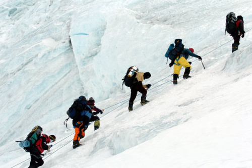 Mountaineers climb towards the pinnacle helping the State Bureau of Surveying and Mapping retake the height of Qomolangma in May 2005. The Tibetan mountain climbing expedition members climbed the 14 highest mountains, more than 8,000 meters high in 14 years. [Photo/Xinhua] 