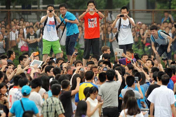 Fans surround British soccer star David Beckham during his visit to Tongji University in Shanghai on Thursday, which resulted in chaotic scenes. Seven people were injured and the rest of Beckham's schedule was canceled. GAO ERQIANG / CHINA DAILY 