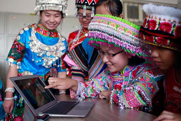 Ethnic Miao students from a middle school in Kunming, Yunnan province, watch astronaut Wang Yapings lesson from the space. FENG YONGBIN / CHINA DAILY