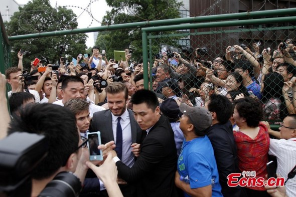 Fans surround David Beckham during his visit to Tongji University in Shanghai, June 20, 2013. The visit resulted in chaotic scenes. Three police officers, two security guards and two students were injured when the former soccer star, now an ambassador for the Chinese Super League, arrived at the college as part of a weeklong China tour. [Photo: Osports] 