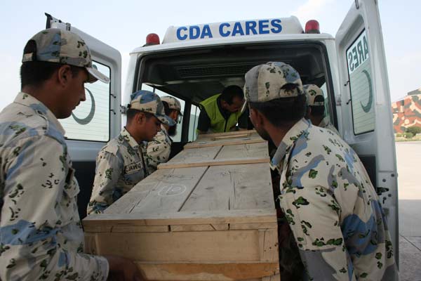 The coffin of a Chinese mountaineer killed by terrorists in Pakistan is carried into a vehicle operated by the city of Islamabad. Zhang Yong / Xinhua