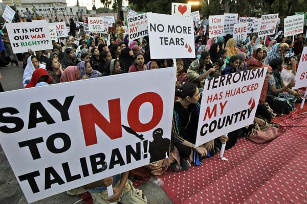 Protesters hold placards to condemn al-Qaida involvement in the killing of 11 mountaineers, in Karachi, Pakistan, on Sunday. Fareed Khan / Associated Press