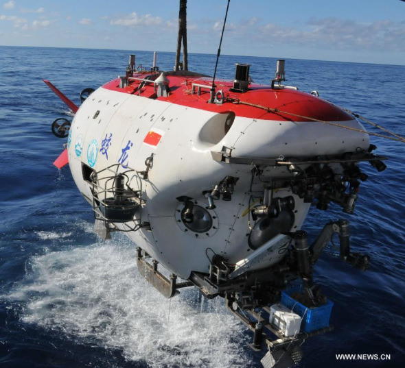 Staff members welcome professor Zhou Huaiyang's coming back by pouring water on him after a deep-sea dive into the south China sea, June 18, 2013.  (Xinhua/Zhang Xudong)