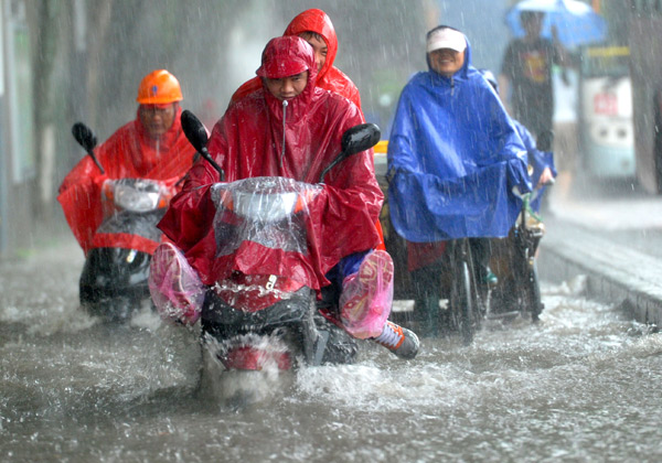 Traveling proves tough during a downpour in Nanjing, capital of Jiangsu province, on Tuesday, as East China is swept by heavy rain. PHOTO BY LANG CONGLIU / FOR CHINA DAILY 